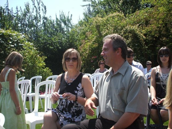 Tom and Theresa Cahill, founders of Cahill Web Studio, sitting together at an outdoor event, symbolizing their journey as digital pioneers and childhood sweethearts.